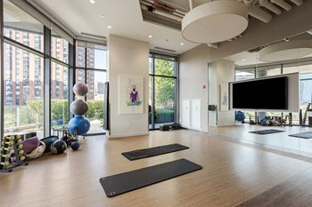 A yoga studio with a large window and exercise equipment.